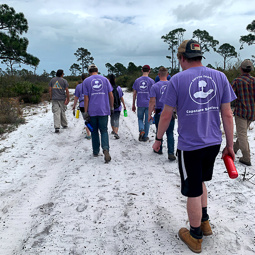 group of students walking away on a white beach