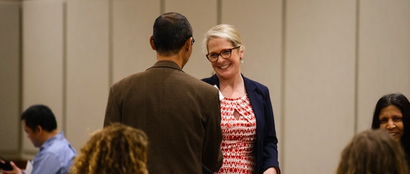 Propel program lead Dr. Emily Devereux greets a faculty researcher at a Propel program event.