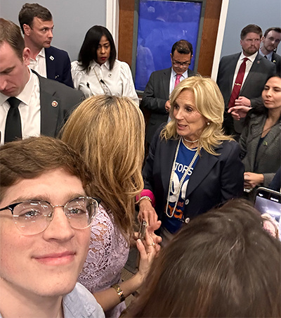 photo of a crowd with a man smiling near Jill Biden