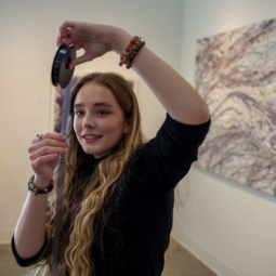 An undergraduate student examines a roll of film in the gallery at Stormwater Studios.