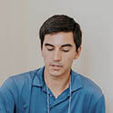 Student in a blue shirt with closed eyes.
