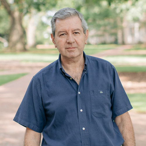 Man with short gray hair wearing a navy blue polo shirt