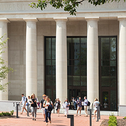 students walking on brick pathway in front of the School of Law.