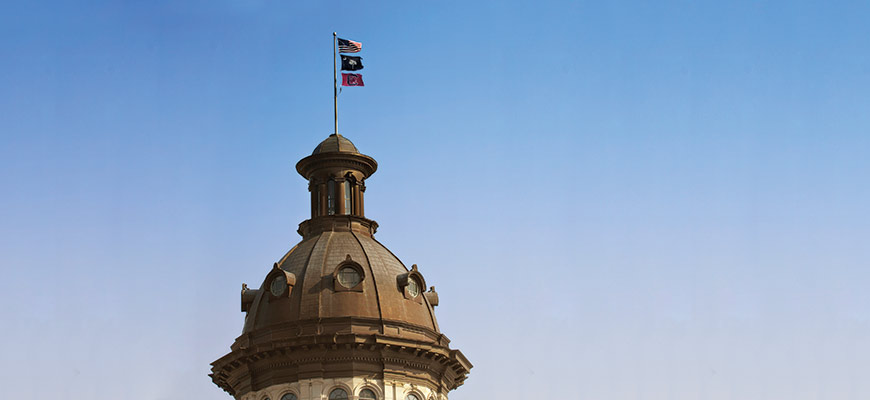 south carolina flag flying on top of the statehouse