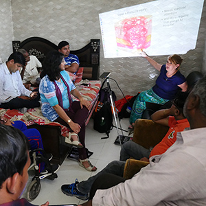 Susan Newman discusses spinal cord injuries to a group in India.