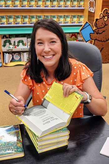 angela may signs a book in bookstore